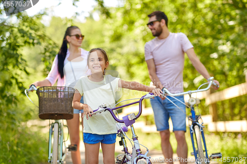 Image of happy family with bicycles in summer park