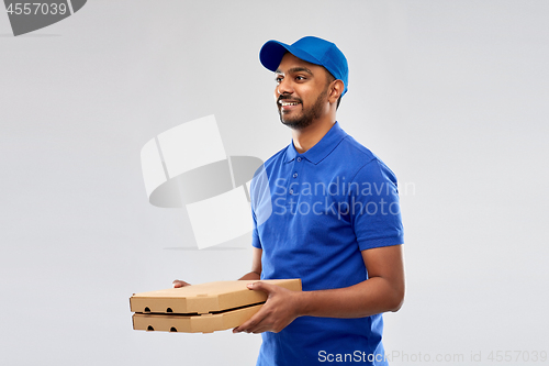 Image of happy indian delivery man with pizza boxes in blue