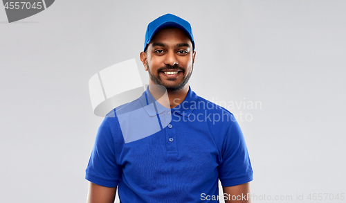 Image of happy indian delivery man in blue uniform