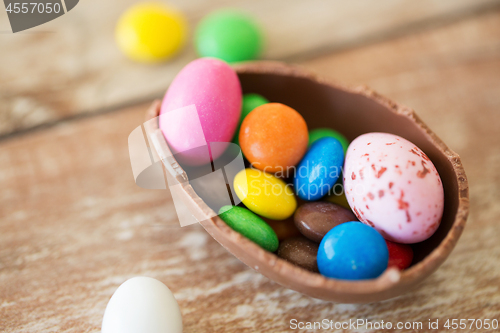 Image of chocolate easter egg and candy drops on table