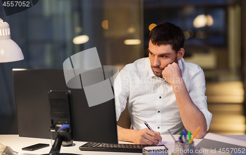 Image of businessman with computer working at night office