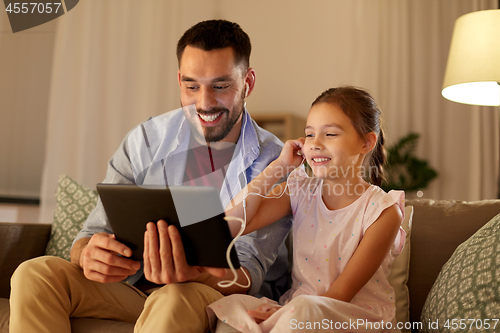 Image of father and daughter listening to music on tablet