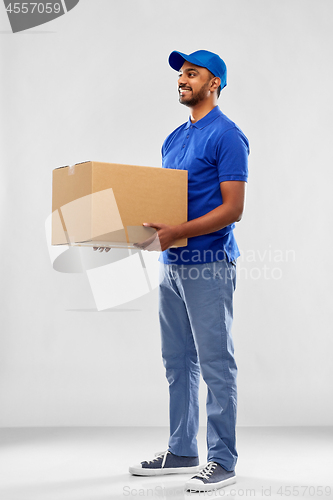 Image of happy indian delivery man with parcel box in blue