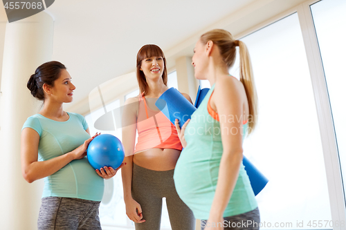 Image of pregnant women with sports equipment in gym