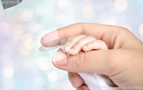 Image of close up of mother and newborn baby hands