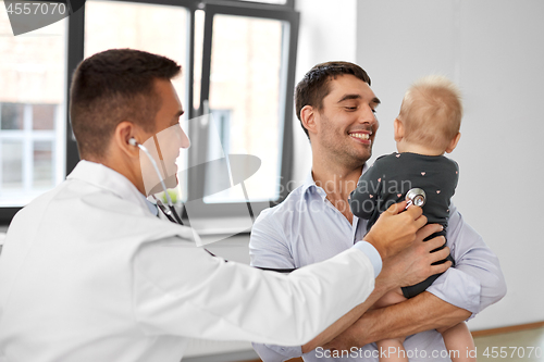 Image of father with baby and doctor at clinic