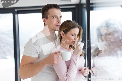 Image of young couple enjoying morning coffee by the window