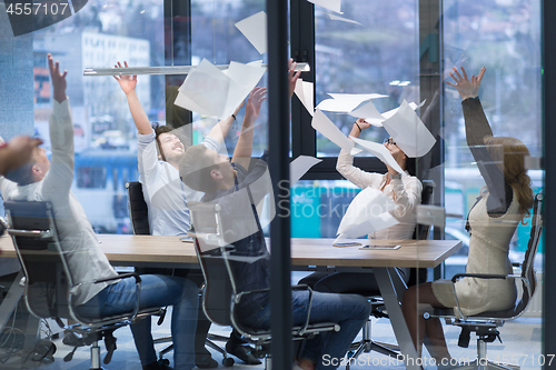 Image of startup Group of young business people throwing documents