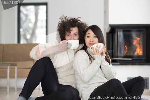 Image of happy multiethnic couple  in front of fireplace