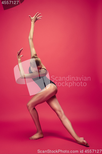 Image of Young teen dancer on red studio background.