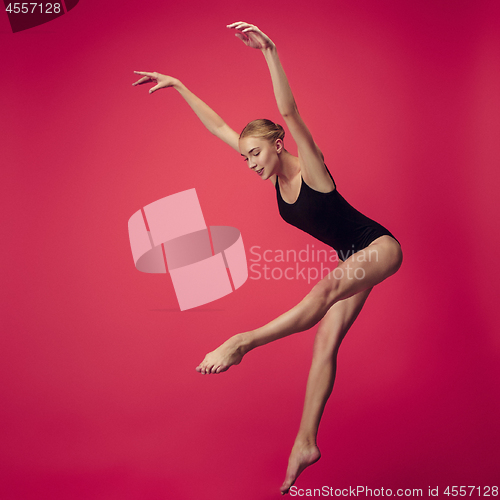 Image of Young teen dancer on red studio background.