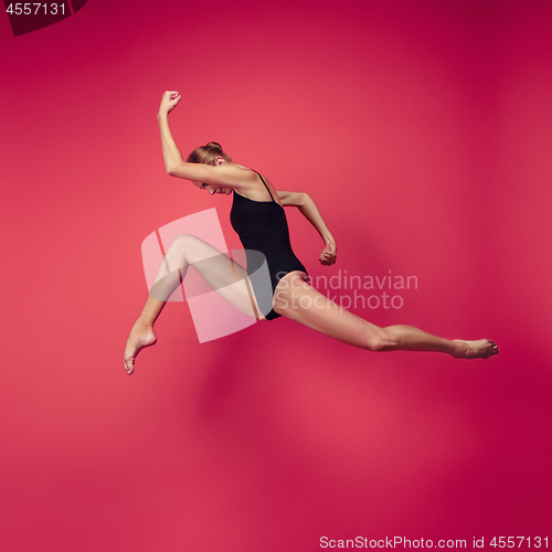 Image of Young teen dancer on red studio background.