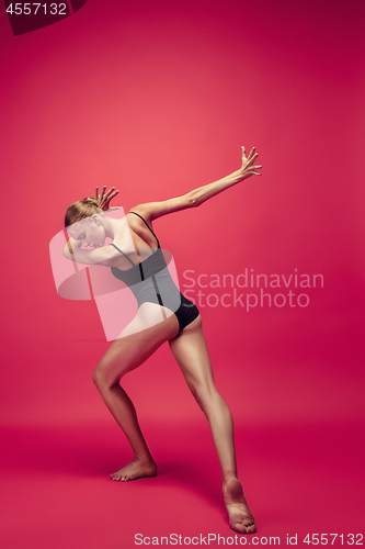 Image of Young teen dancer on red studio background.