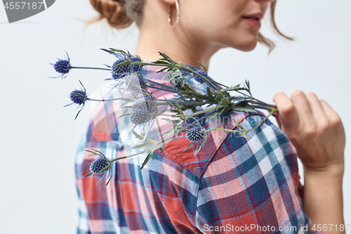 Image of Young girl with flowers eryngium