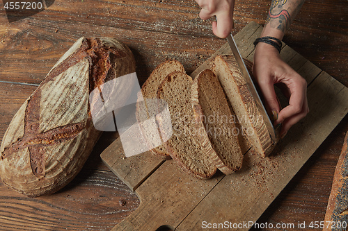 Image of Women\'s hands cut organic bread