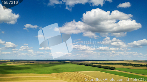 Image of Rural scenic landscape with blue sky and clouds, green fields, yellow meadows in a summer sunny day. Panoramic view from drone.