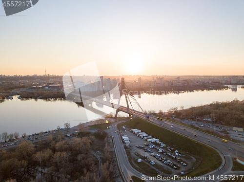 Image of North Bridge with a large parking for cars over the Dnieper River and a view of the Skaimol shopping center in the Obolon area