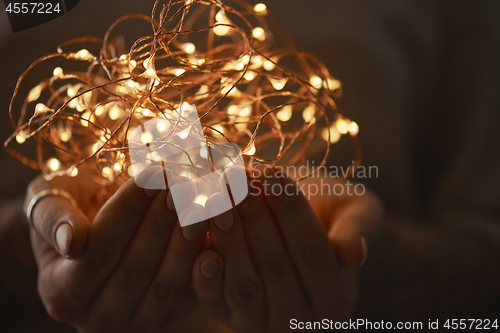 Image of bright christmas lights in woman\'s hands