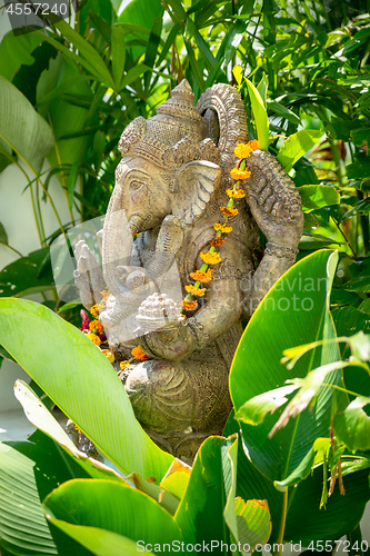 Image of Garland of golden flowers draped around Ganesha