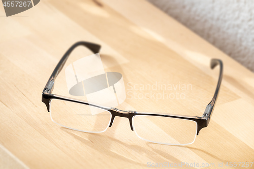 Image of reading glasses on a wooden table