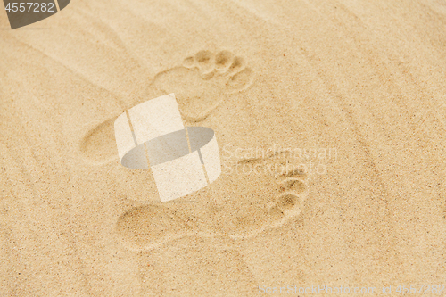 Image of footprints in sand on summer beach