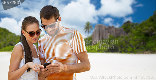 Image of happy couple with smartphone on seychelles island