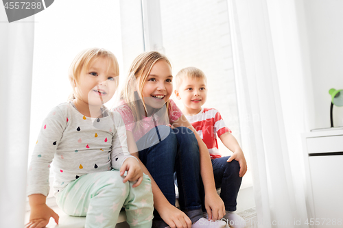 Image of happy little kids sitting on window sill