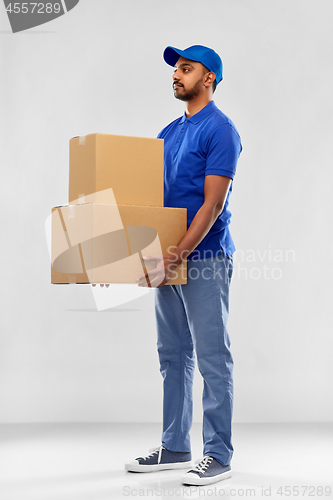 Image of indian delivery man with parcel boxes in blue