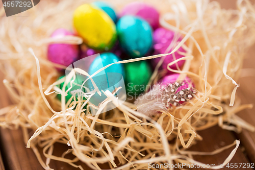 Image of chocolate easter eggs in straw nest on table