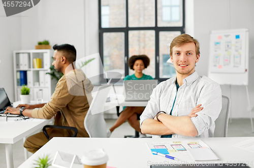 Image of male creative worker with laptop at office