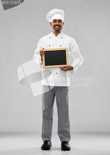 Image of happy male indian chef in toque with chalkboard