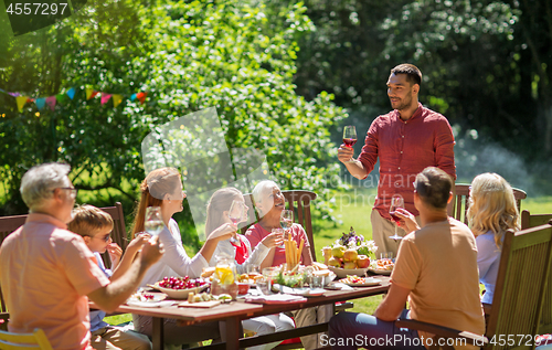 Image of happy family having dinner or summer garden party