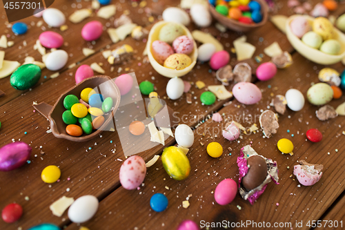 Image of chocolate eggs and candy drops on wooden table