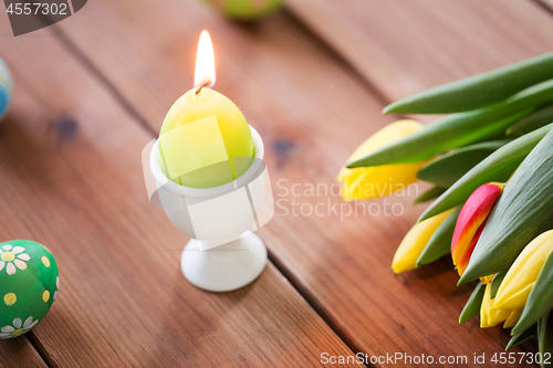 Image of candle in shape of easter egg and tulip flowers