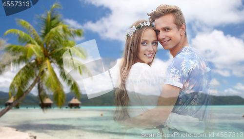 Image of hippie couple fading over exotic beach background