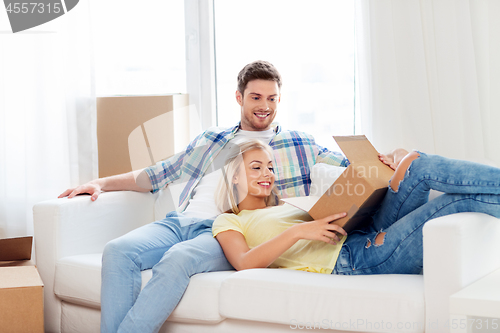 Image of happy couple opening parcel box at home