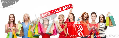 Image of happy women with shopping bags and sale sign