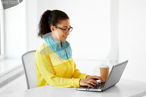 Image of creative woman with laptop and coffee at office