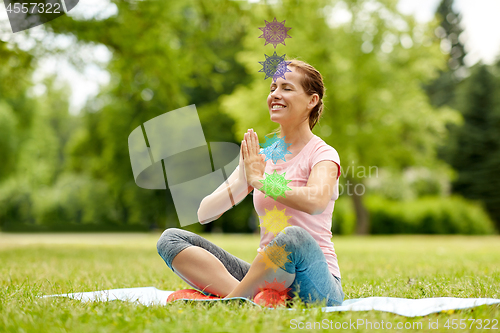 Image of happy woman meditating in summer park