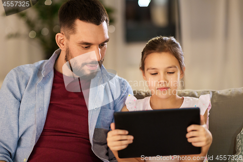 Image of father and daughter with tablet computer at home