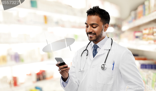 Image of smiling indian male doctor with smartphone
