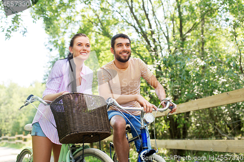 Image of happy couple with bicycles at summer park