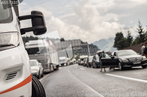 Image of Typical scene on European highways during summer holiadays rush hour. A traffic jam with rows of cars tue to highway car accident. Empty emergency lane. Shallow depth of field