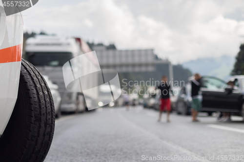 Image of Typical scene on European highways during summer holiadays rush hour. A traffic jam with rows of cars tue to highway car accident. Empty emergency lane. Shallow depth of field
