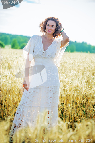 Image of smiling beautiful middle aged woman in the field