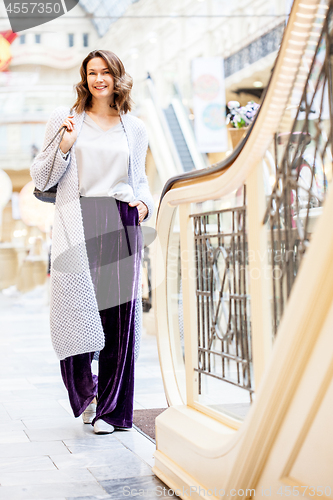 Image of smiling beautiful woman in a light knitted coat