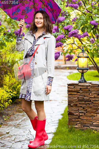 Image of woman dressed up in a raincoat with an umbrella