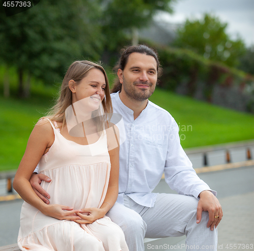 Image of A young man and a pregnant woman in bright clothes