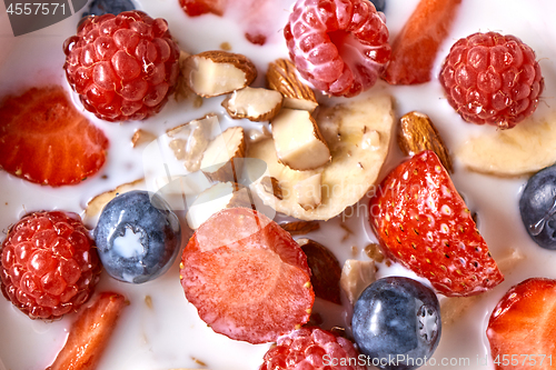 Image of Close up of natural fresh ingredients with healthy breakfast - strawberry, blueberry, chopped almonds, granola and fresh milk. Top view.