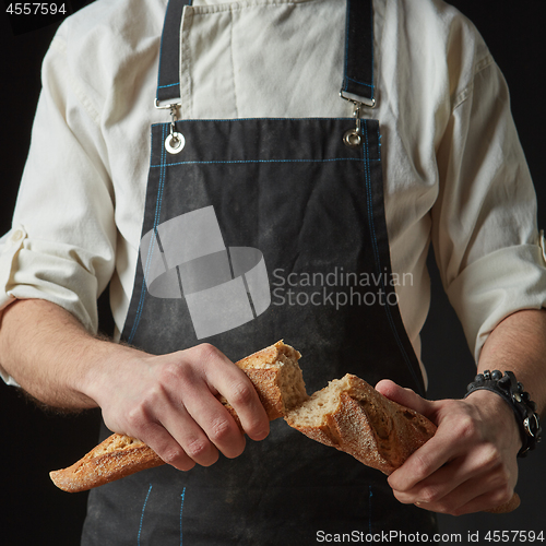 Image of Male hands break the baguette